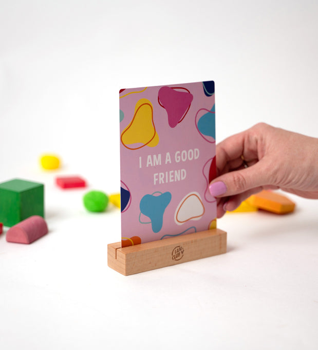 i am a good friend affirmation card for children in a wooden stand and a white background