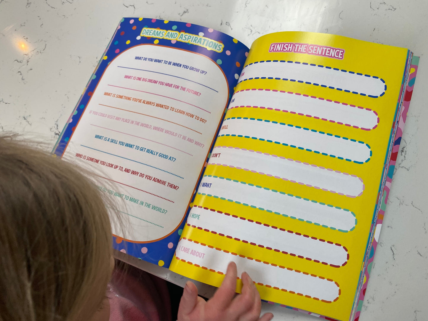 young girls hand holding the book down to read the this is me journal on the dreams and aspirations pages